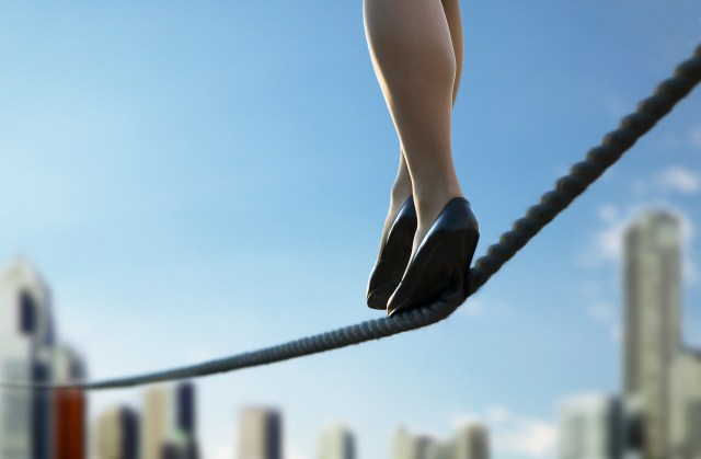 Unstable job - Low section of a business person walking on thin red line. Credit: D-BASE / Getty 