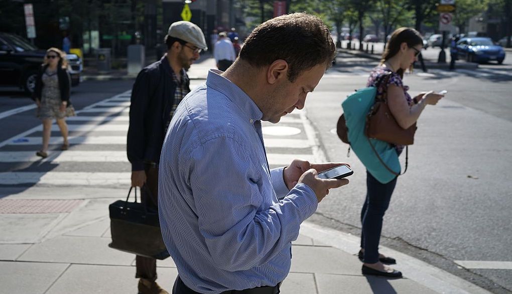 Commuters on their phone. Credit: Getty.