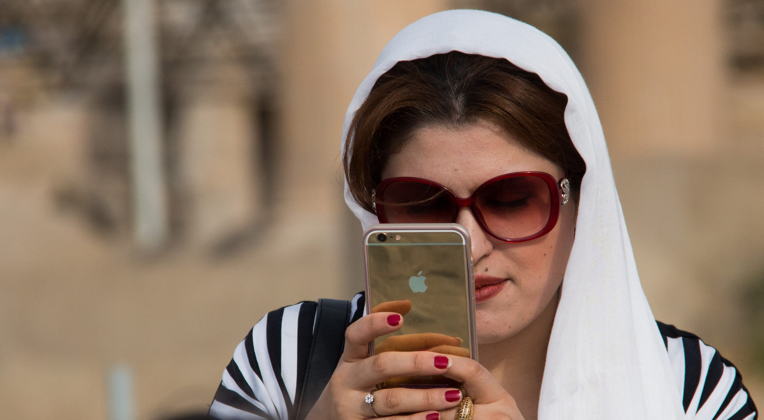 A woman checks her smartphone in Iran. Credit: Getty