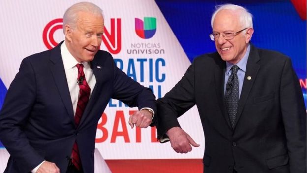 Joe Biden and Bernie Sanders exchange a corona-shake before their head-to-head debate.