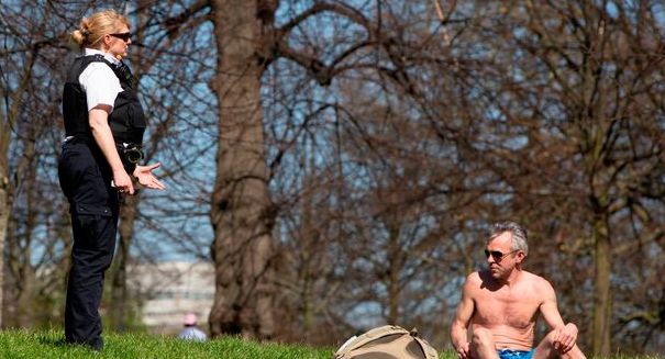 A police officer orders a sun-bather to leave
