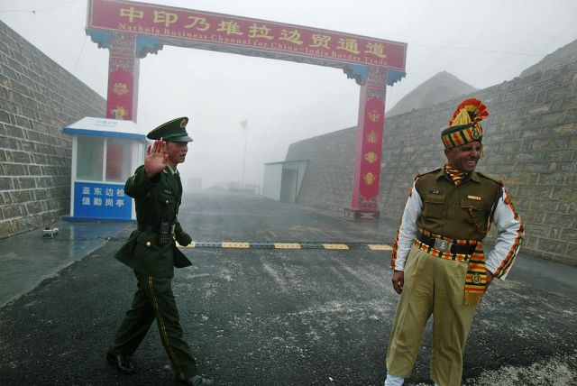 Tensions simmer along the 2,100-mile-long border: a Chinese soldier and an Indian soldier stand guard at the  Nathu La border crossing. (Photo: DIPTENDU DUTTA/AFP via Getty Images)