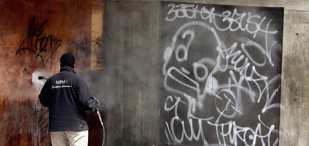 A graffiti cleaning specialist steam cleans the walls of the Hayward Gallery (Photo by Bruno Vincent/Getty Images)