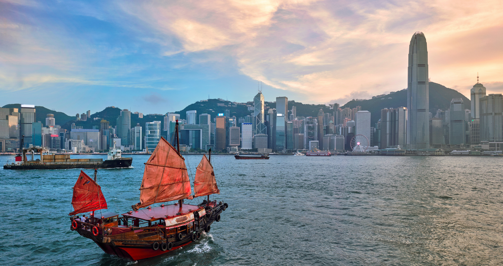 Victoria Harbour, Hong Kong with a junk tourist ferry boat. Credit: Getty