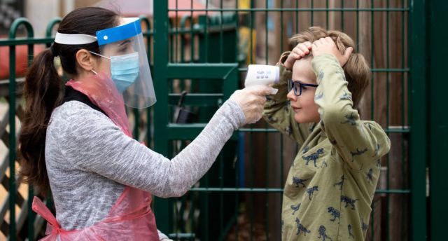 A member of staff wearing PPE takes a child's temperature at Shortland's school in London. (Photo by Dan Kitwood/Getty Images)