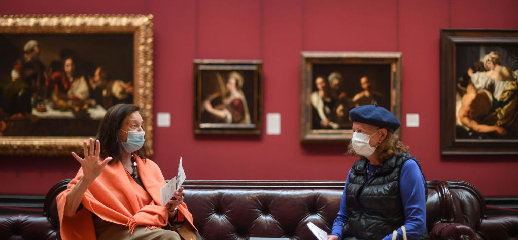 Two women wear masks while viewing paintings at the National Portrait Gallery. Credit: Getty