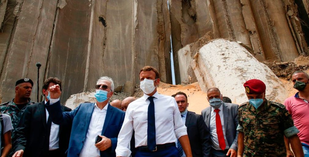 French President Emmanuel Macron, surrounded by Lebanese servicemen, visits the devastated site of the explosion at the port of Beirut. Credit: Thibault Camus / Getty Images 