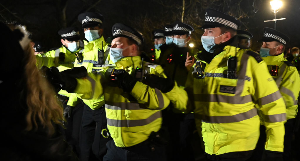 Police Officers arrest a woman during a vigil on Clapham Common