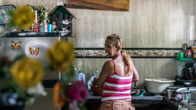 Doris, who was raped with her sister in Colombia's civil war, does the dishes in her home in Fundación. © NicholeSobecki/VII