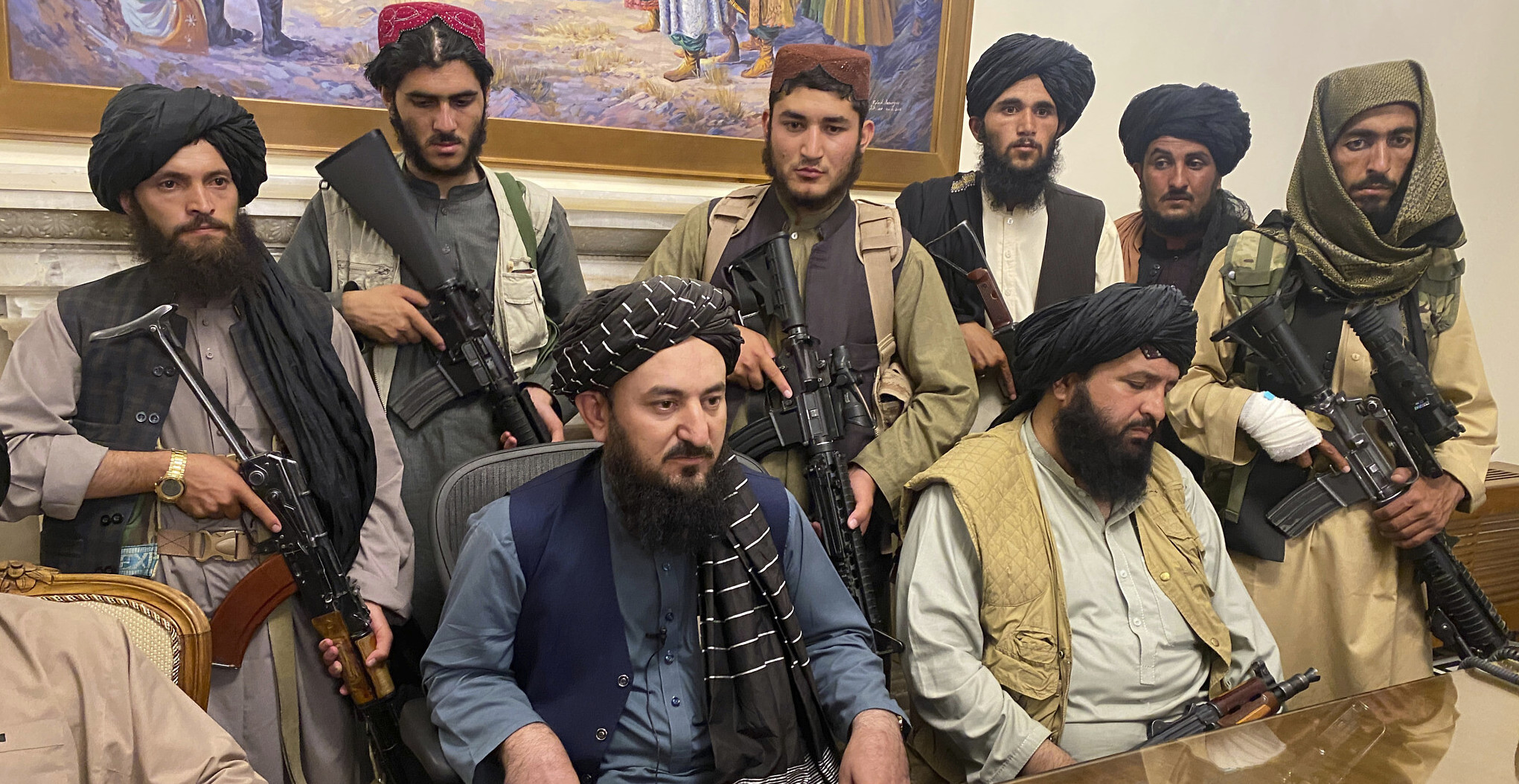 Taliban fighters discuss monetary policy in Kabul presidential palace