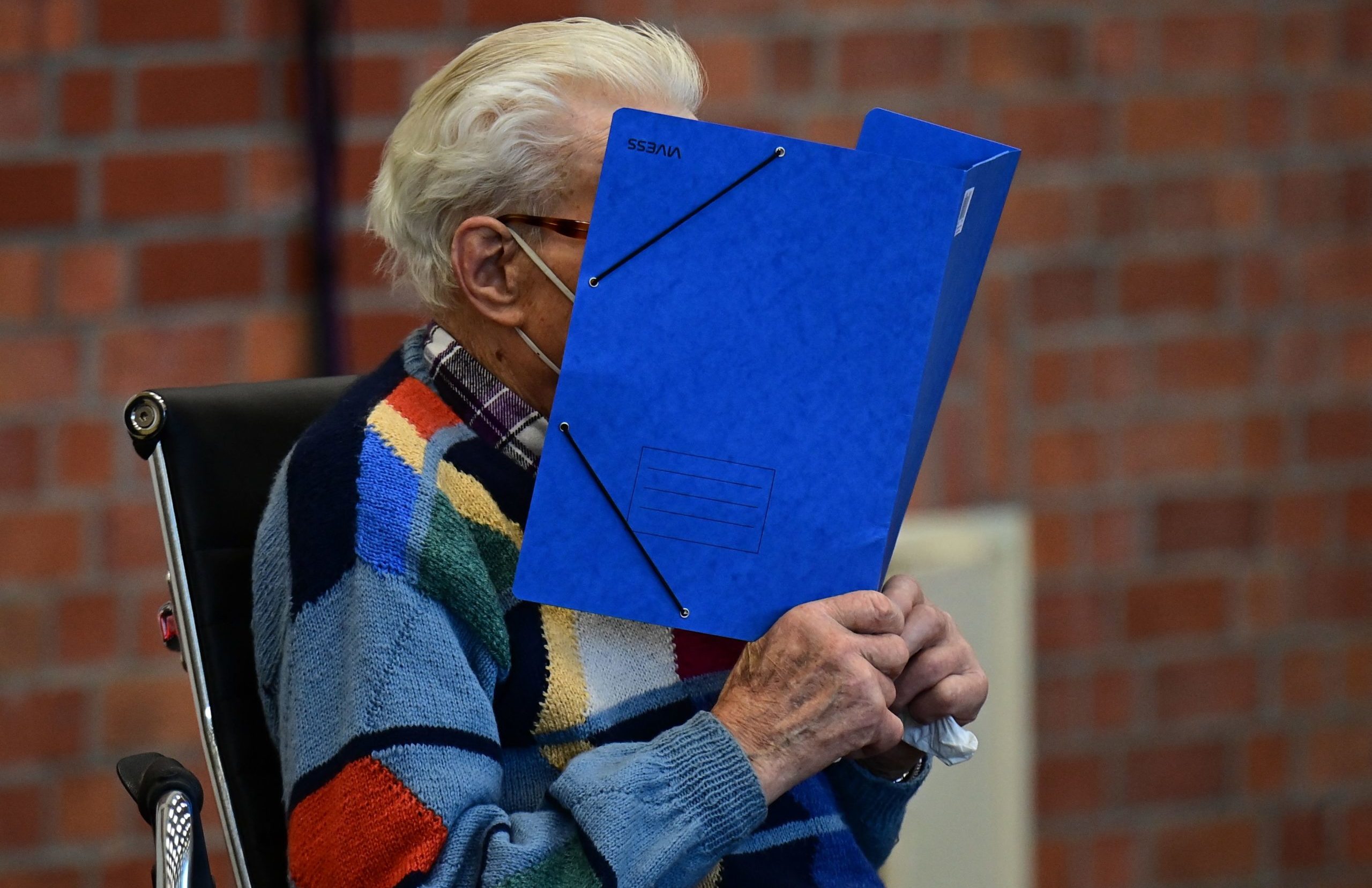 Defendant Josef S hides his face behind a folder as he arrives for his trial in Brandenburg an der Havel, northeastern Germany, on October 7, 2021.  (Photo by Tobias Schwarz / AFP) (Photo by TOBIAS SCHWARZ/AFP via Getty Images)