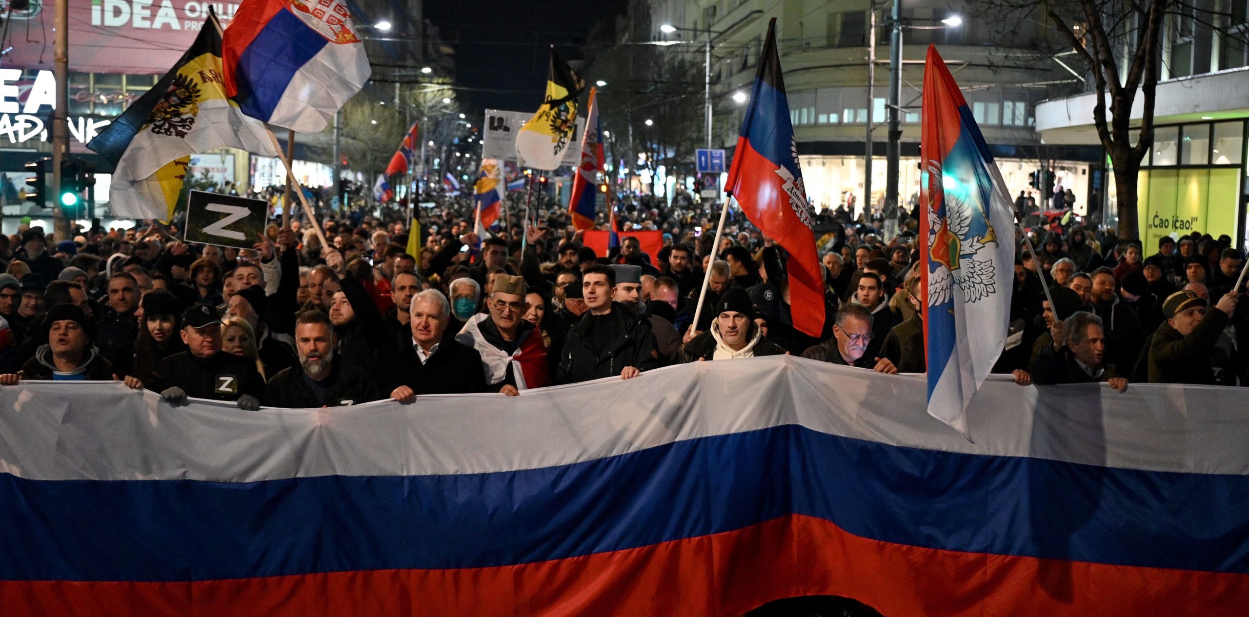 People wave Russian and Serbian flags during a rally in Belgrade. Credit: Getty