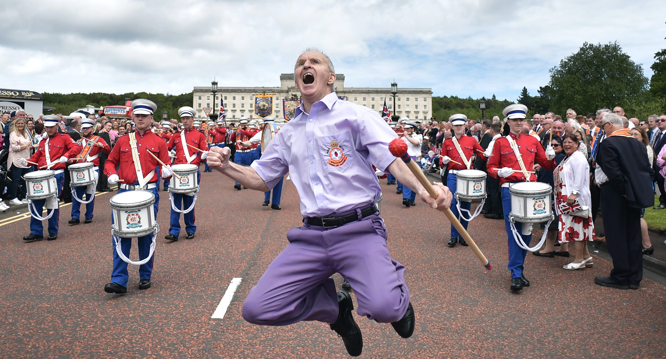 An Orange bandsman jumps as he leads his band at Stormont. Credit: Getty