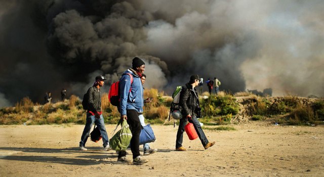Migrants leave the destroyed 'Jungle' camp (Christopher Furlong/Getty Images)