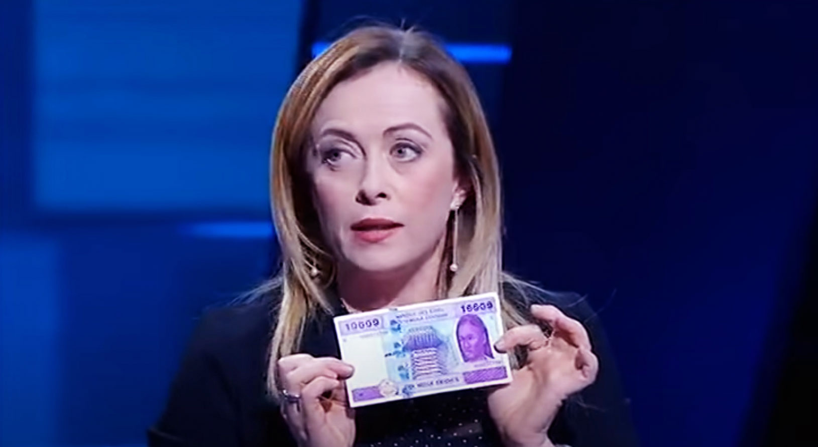 Giorgia Meloni holds up a CFA Franc note in a 2019 interview.