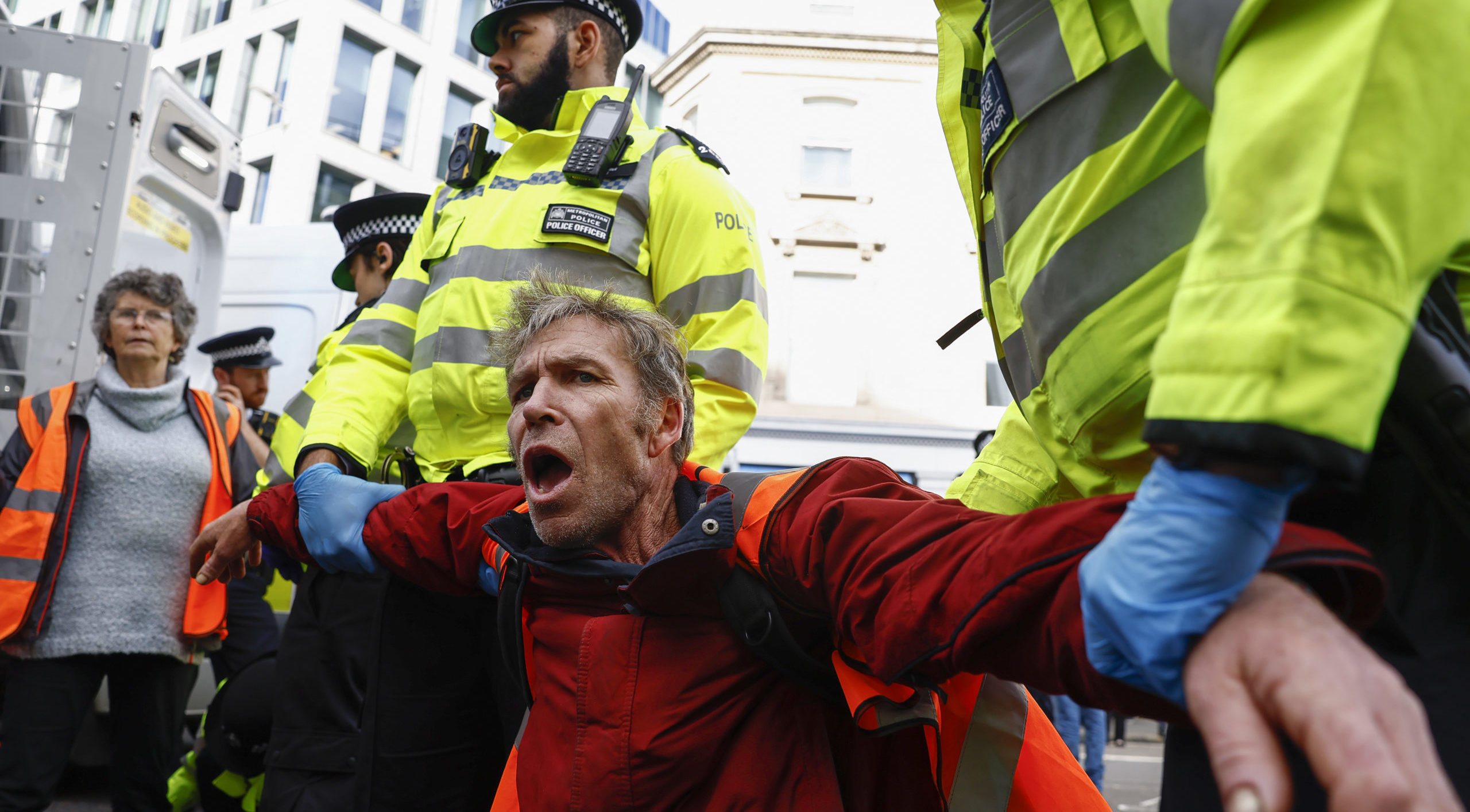 A Just Stop Oil protestor is escorted away by police. Credit: Getty.