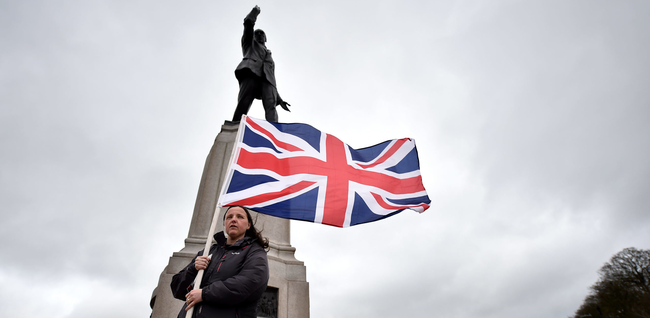 A unionist stands under  the statue of Edward Carson outside Northern Ireland's Parliament Buildings. Credit: Getty.