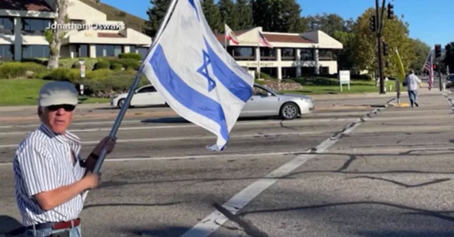 Paul Kessler holding an Israeli flag. Credit: Jonathan Oswaks