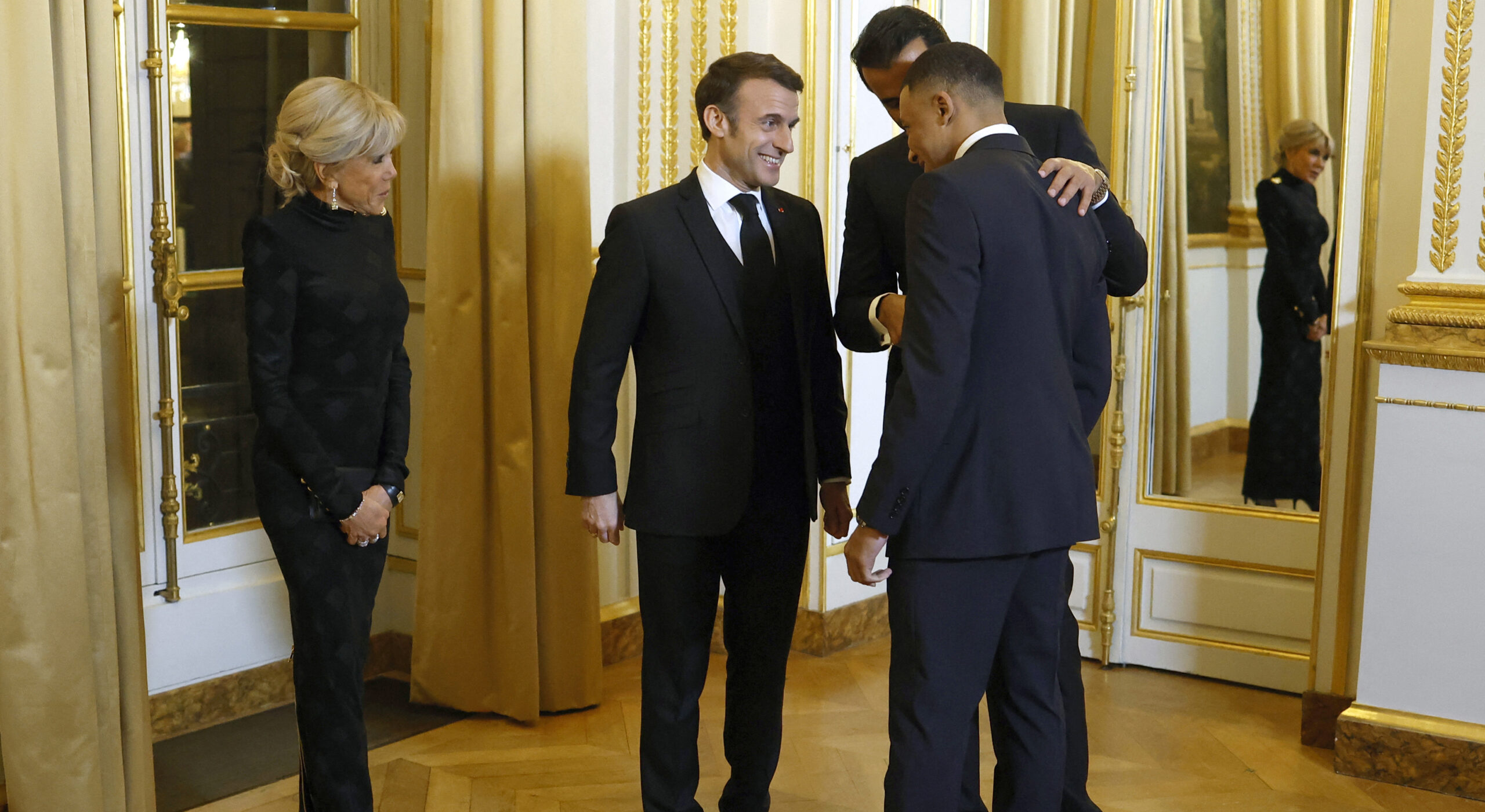 Emmanuel Macron (2L), French First Lady Brigitte Macron (L) and Qatari Emir Sheikh Tamim bin Hamad Al Thani greet Kylian Mbappe. Credit: Getty