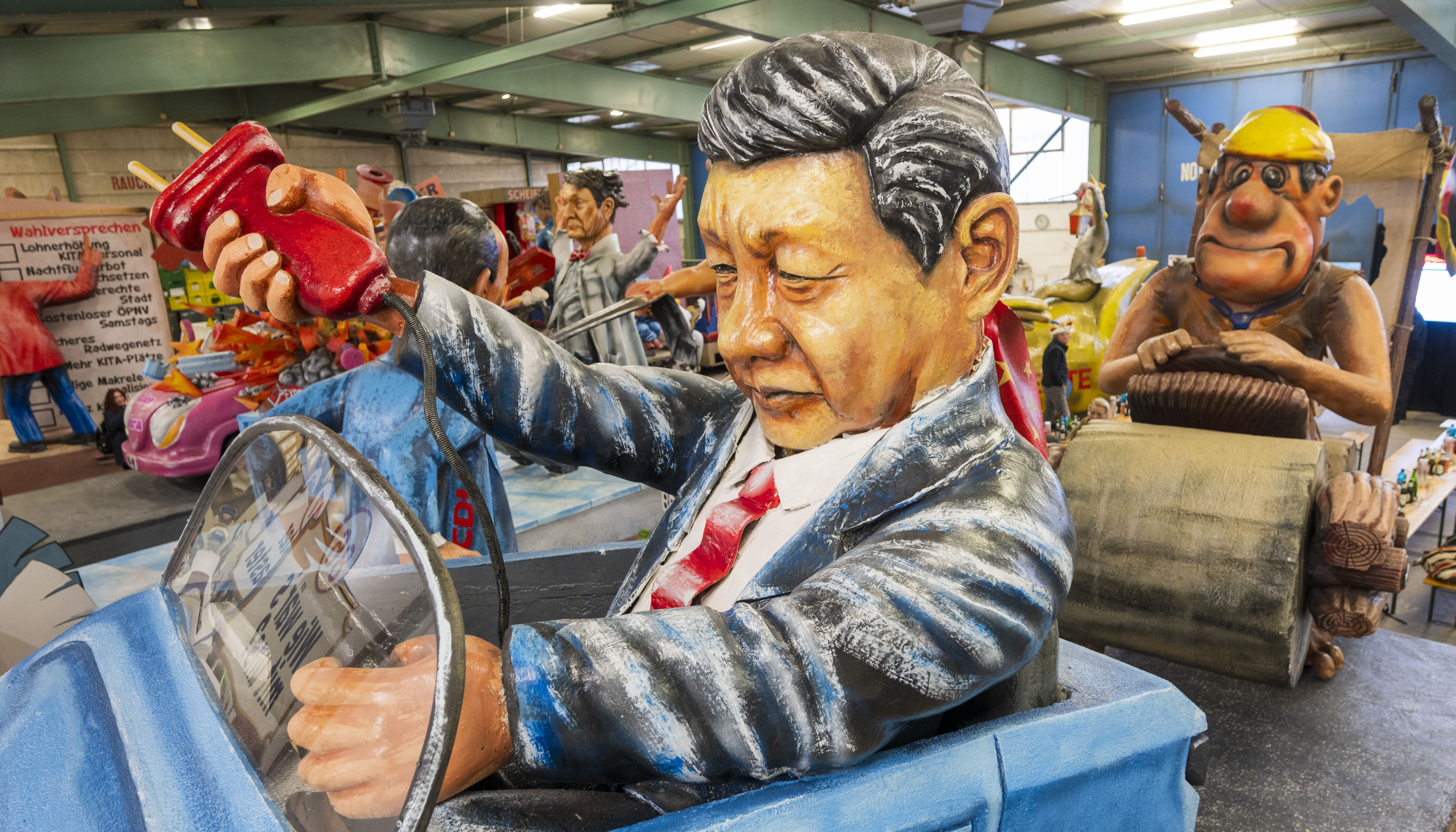 A float in Germany depicts Xi Jinping pulling the plug on an electric car and leaving German carmakers behind. Credit: Getty