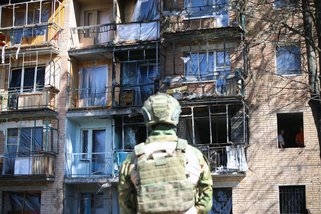 A local volunteer looks at a building damaged by Ukrainian strikes in Kursk. Credit: Getty
