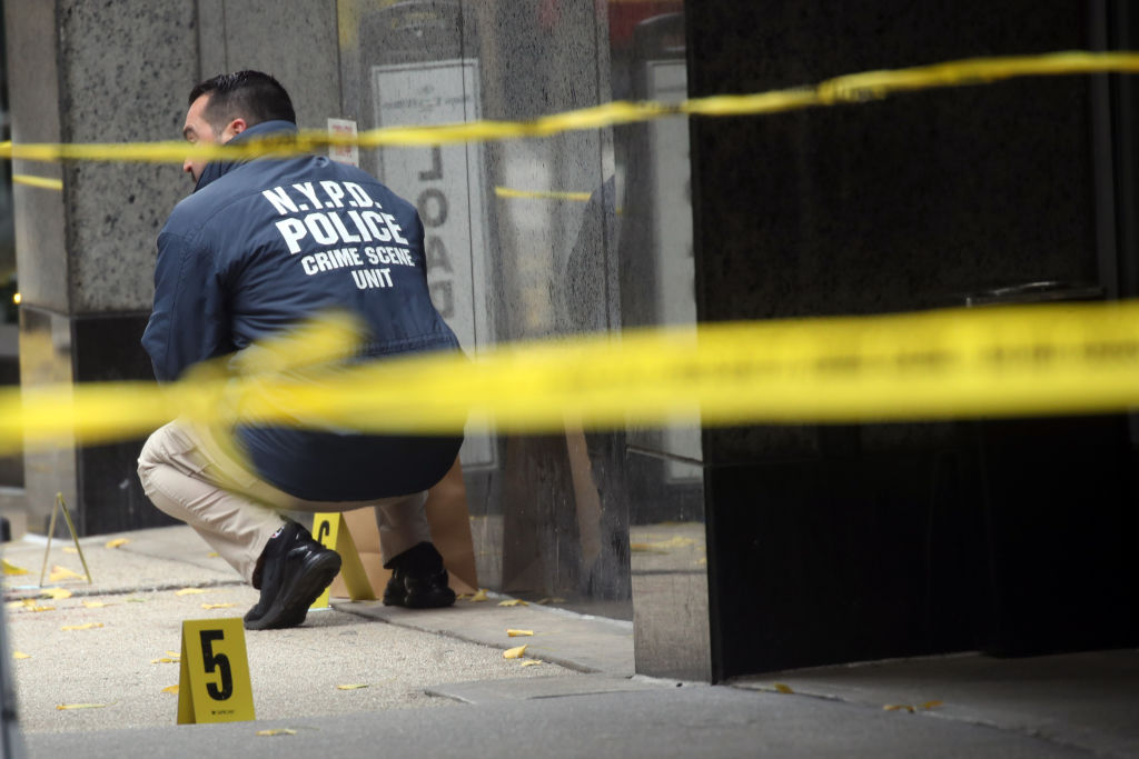 Police inspect the Brian Thompson crime scene on Wednesday. Credit: Getty