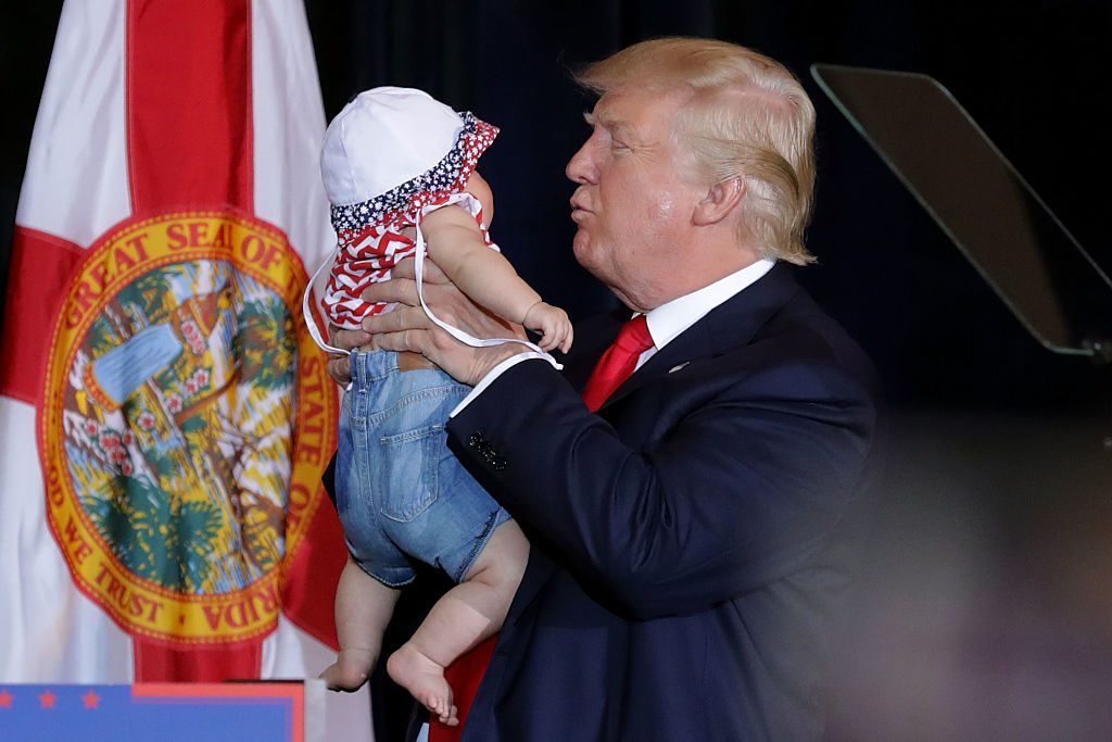 Trump kissing a baby on the campaign trail. Credit: Getty