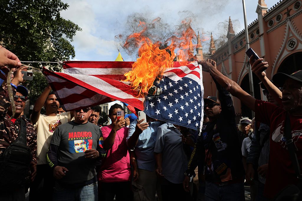 Maduro supporters burn a US flag in Caracas on Saturday. Credit: Getty