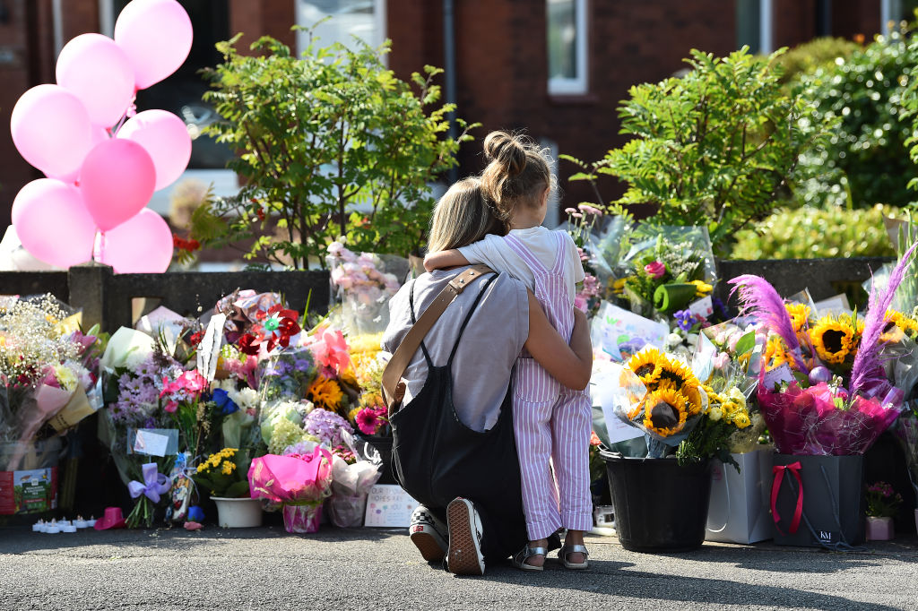 A mother and her child gather at a memorial to the Southport victims in 2024. Credit: Getty
