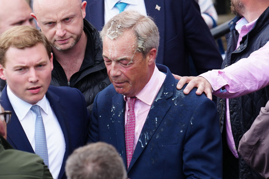Farage pictured with George Cottrell (left) when the Reform UK leader had a milkshake thrown at him by a member of the public. Credit: Getty